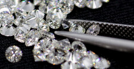 Many small diamond close up and Diamond tweezers on black background