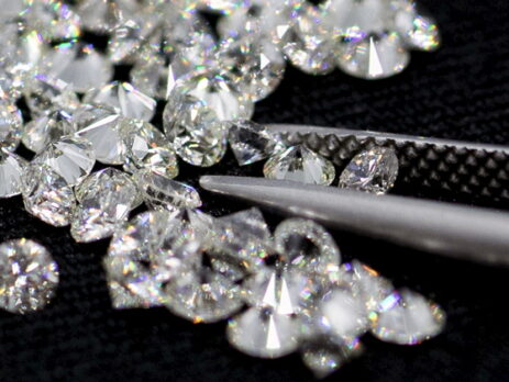 Many small diamond close up and Diamond tweezers on black background
