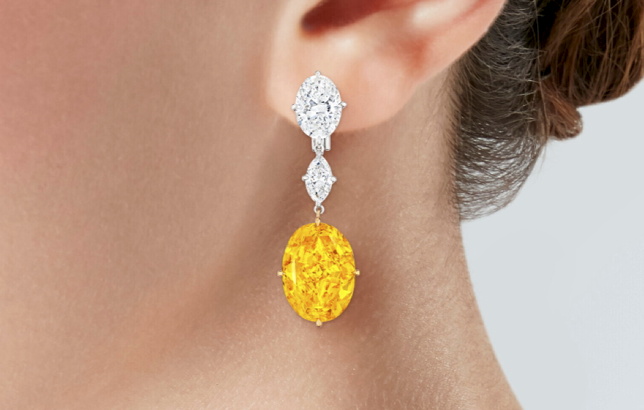 Earrings featuring a pair of exceptionally large fancy vivid orange-yellow diamonds, weighing 12.20 carats and 11.96 carats are to be sold at Christie's New York.
